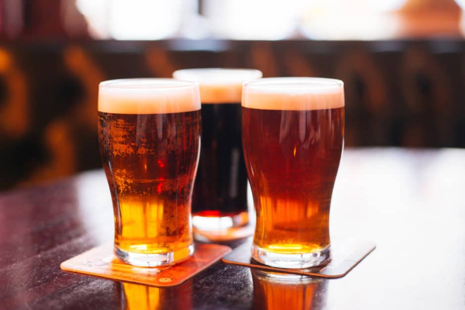 Glasses of light and dark beer on a pub background.