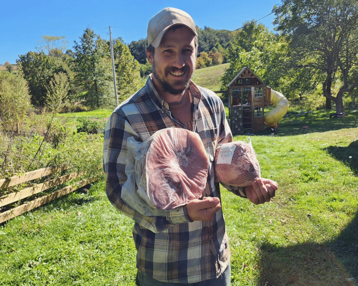 Josiah Meck of Honey Brook Farm holding ham.