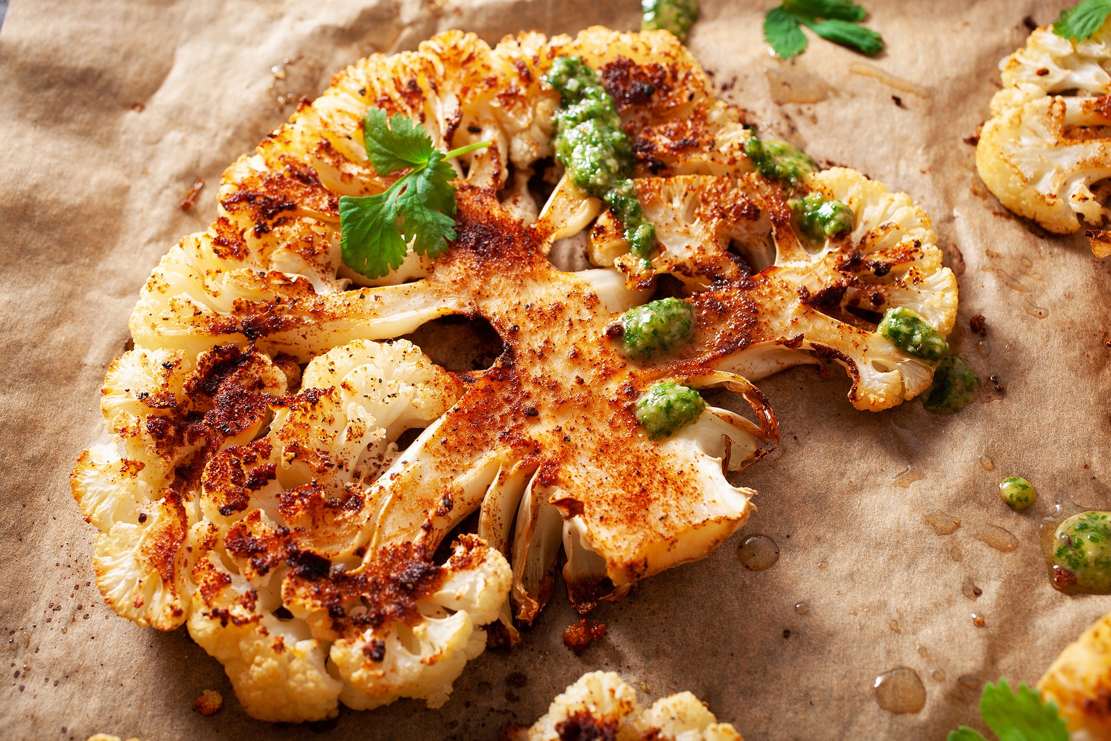 Cauliflower steaks with herb and spice on baking tray. plant based meat substitute.