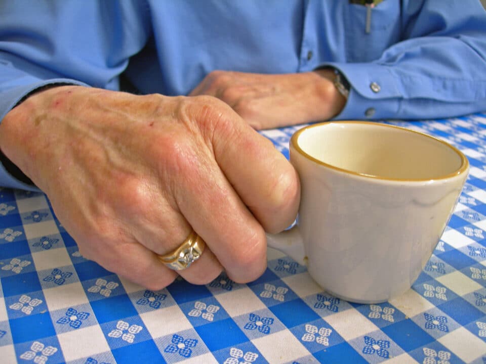 elderly man holding coffee cup-close up shot.