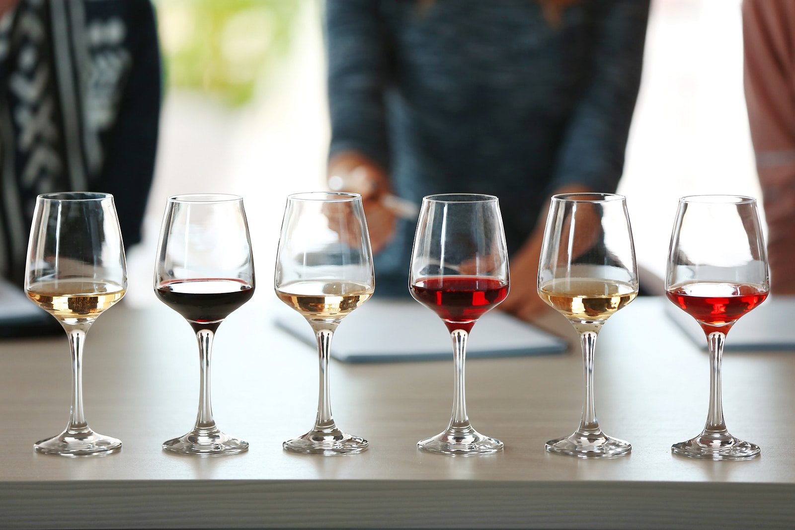 Many glasses of different wine in a row on a table. Tasting wine concept.