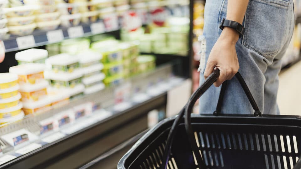 Closeup of woman's hand holding empty market basket doing shopping at supermarket or grocery with. Sale, shopping, consumerism and people concept. Copy space.