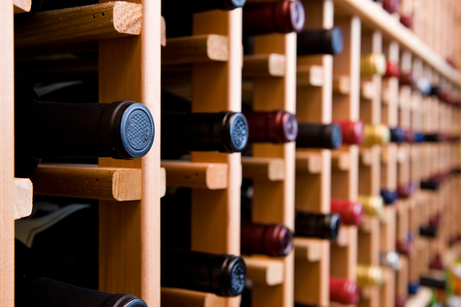 Wine cellar with bottles stacked in wooden rack.
