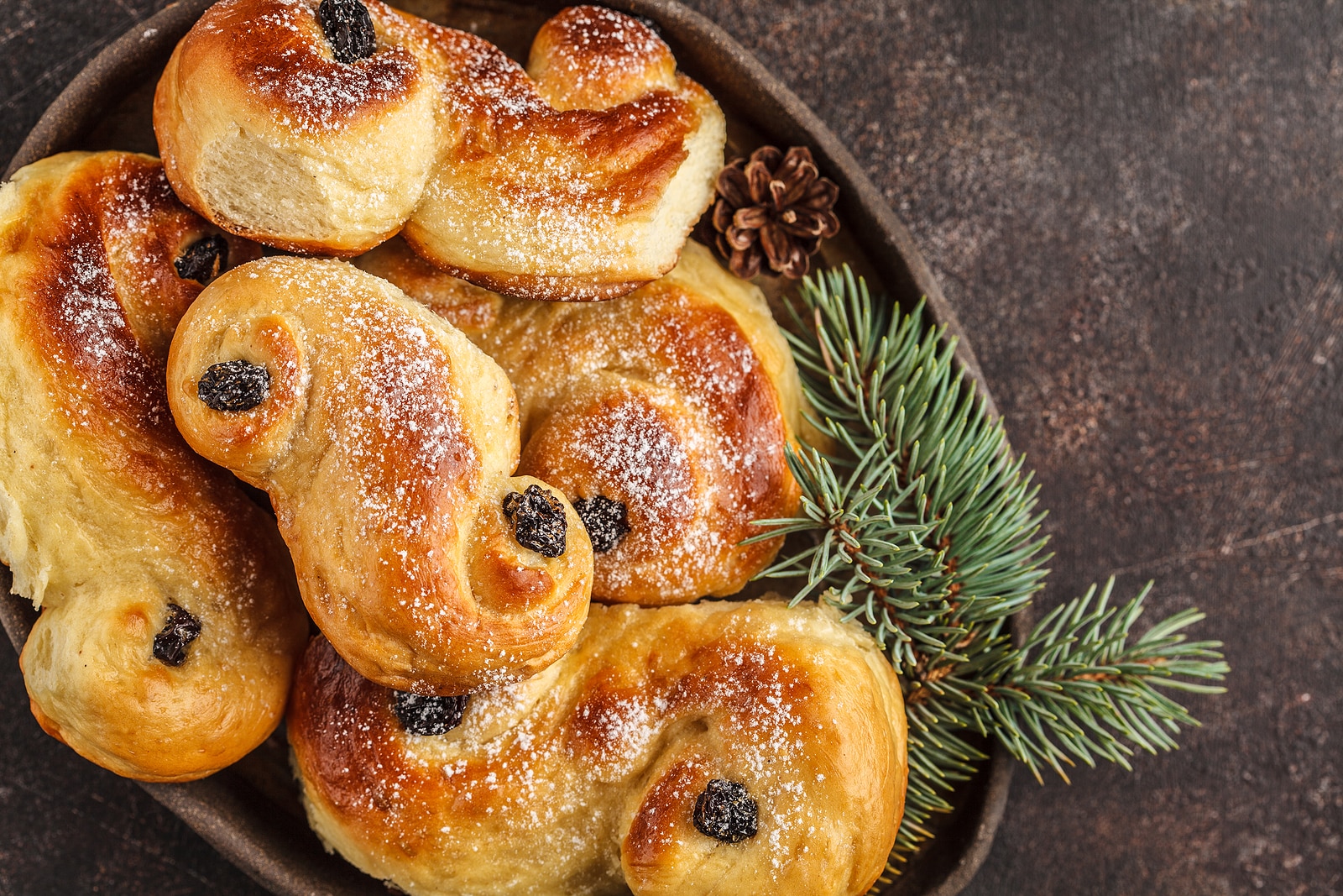 Traditional Swedish Christmas saffron buns (lussebulle or lussekatt). Swedish christmas. Dark background, Christmas decoration..