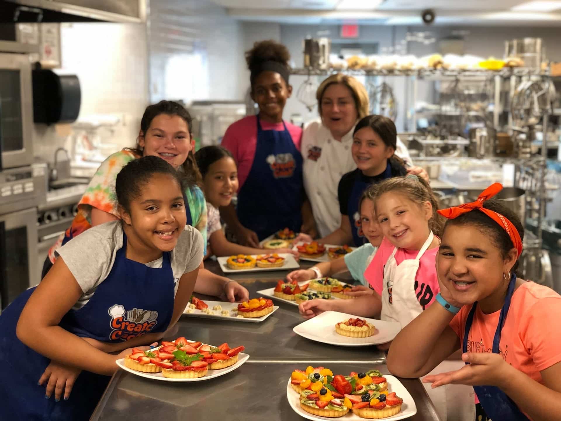 Girls make fruit tarts at Create-a-Cook.